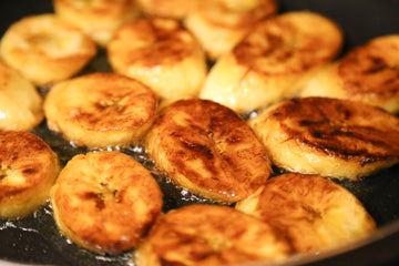 Plantains browning in a pan.